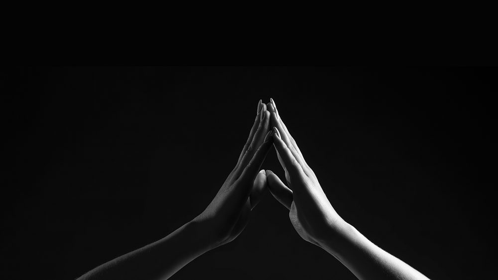 Hands put together in black and white. Photo.